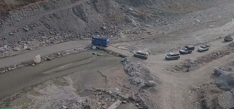 बिपी राजमार्गमा जोखिमपूर्ण यात्रा : रोशी खोलाको अस्थायी कच्ची सडकले बढायो दुर्घटनाको जोखिमरामेछाप ।